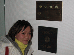Miaomiao with a sign of the Lions Club in the city center