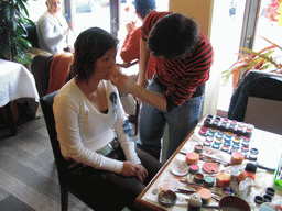 Miaomiao getting face paint at a restaurant in the city center