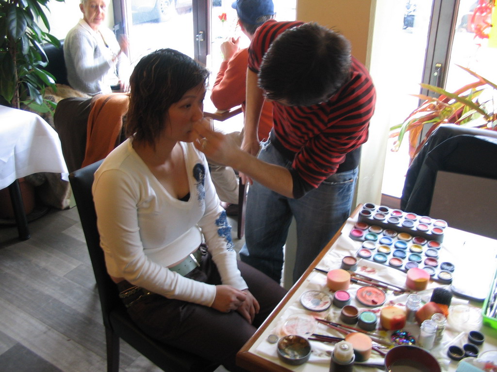 Miaomiao getting face paint at a restaurant in the city center