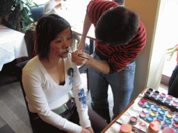 Miaomiao getting face paint at a restaurant in the city center