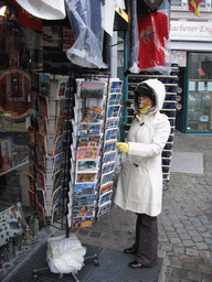 Miaomiao wtih face paint looking at postcards at a shop at the Spitzgässchen street