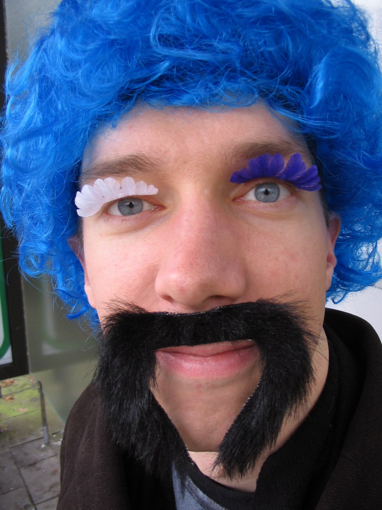 Tim with a wig, fake eyelashes and a fake mustache at the Buschhausen bus stop at the Kornelimünsterweg street