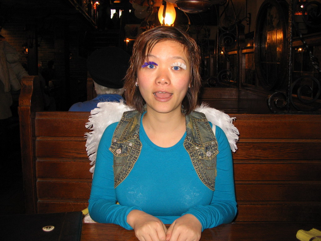 Miaomiao with fake eyelashes and angel wings at a restaurant in the city center