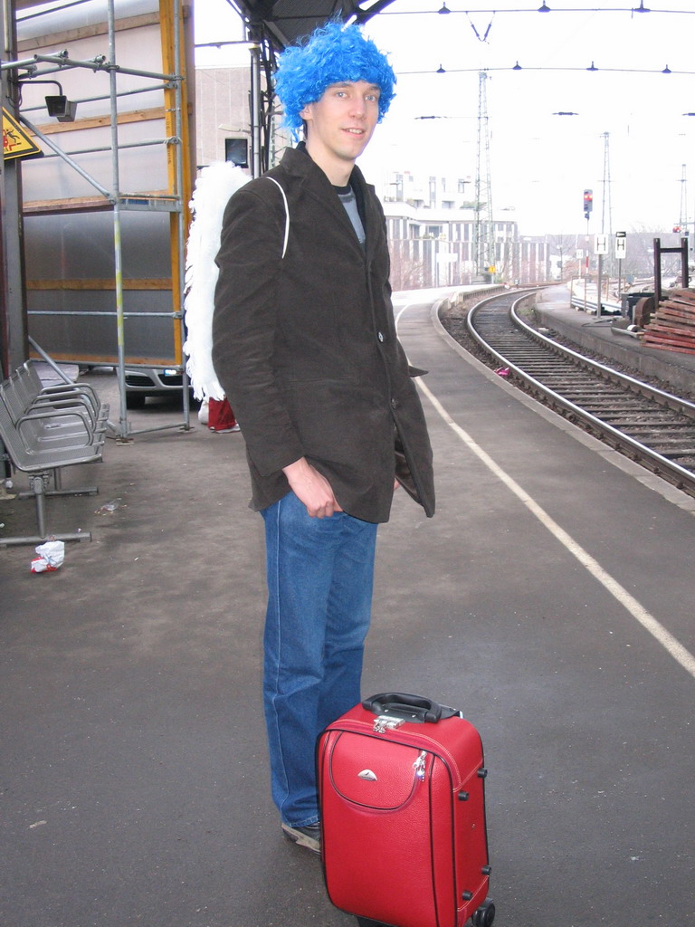 Tim with a wig and angel wings at the Aachen Railway Station