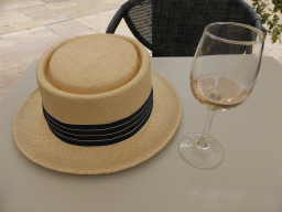 Miaomiao`s hat and a glass of wine at the Le Darius café at the Avenue Giuseppe Verdi