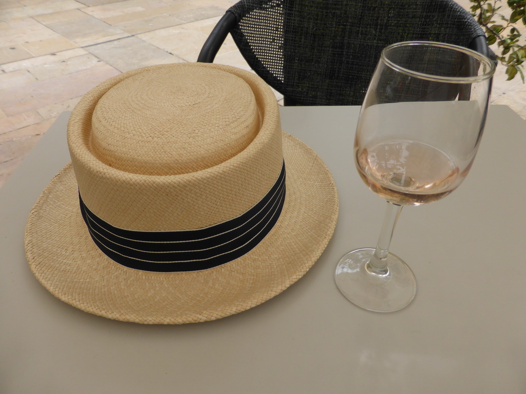Miaomiao`s hat and a glass of wine at the Le Darius café at the Avenue Giuseppe Verdi