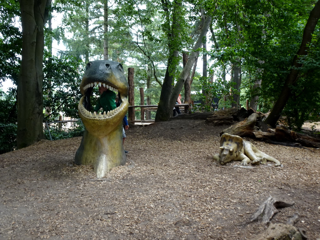 Dinosaur head and Triceratops statue at a playground at the DinoPark at the DierenPark Amersfoort zoo