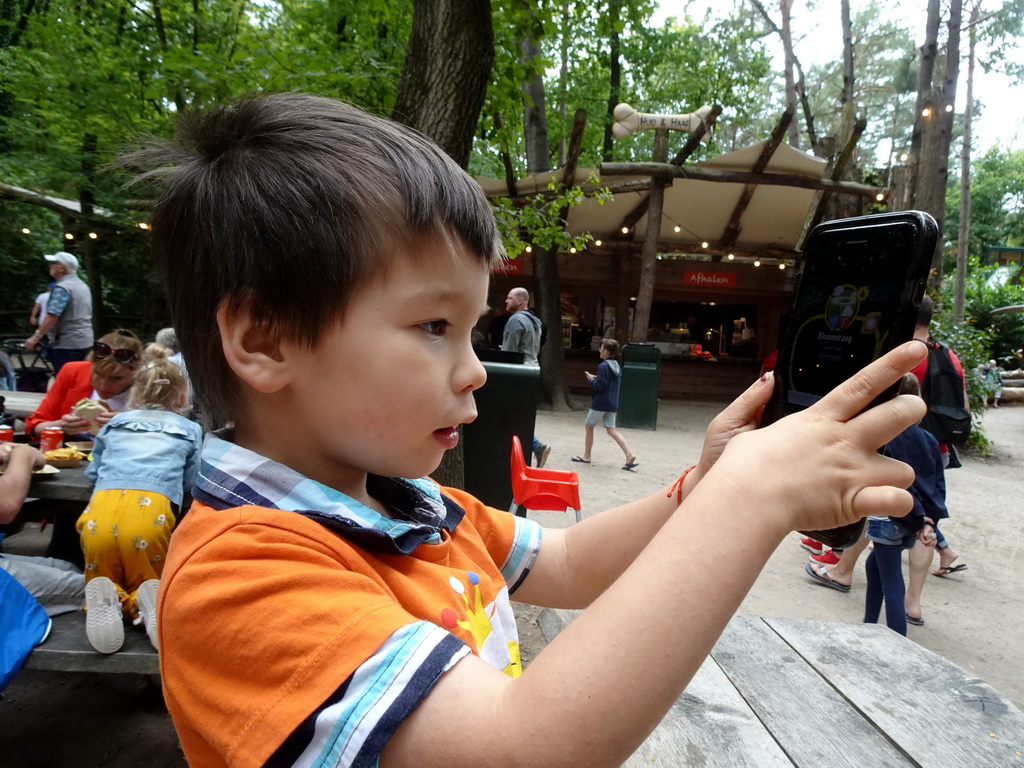 Max playing with iPhone at the terrace of the Huid & Haar restaurant at the DinoPark at the DierenPark Amersfoort zoo