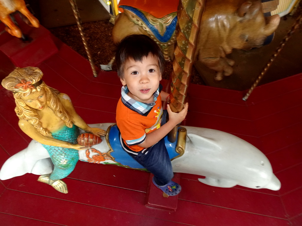 Max on a Dolphin statue at the Carousel at the Pretplein square at the DierenPark Amersfoort zoo