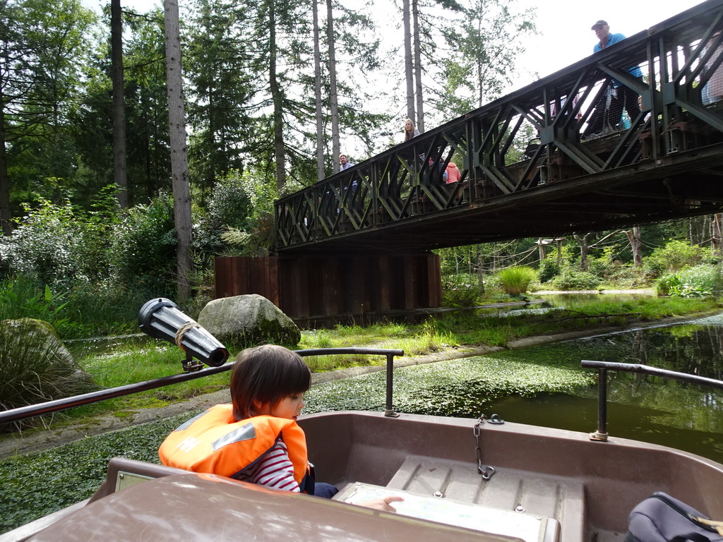 Max on the cycle boat on the Expedition River at the DierenPark Amersfoort zoo, with a view on the Bailey Bridge