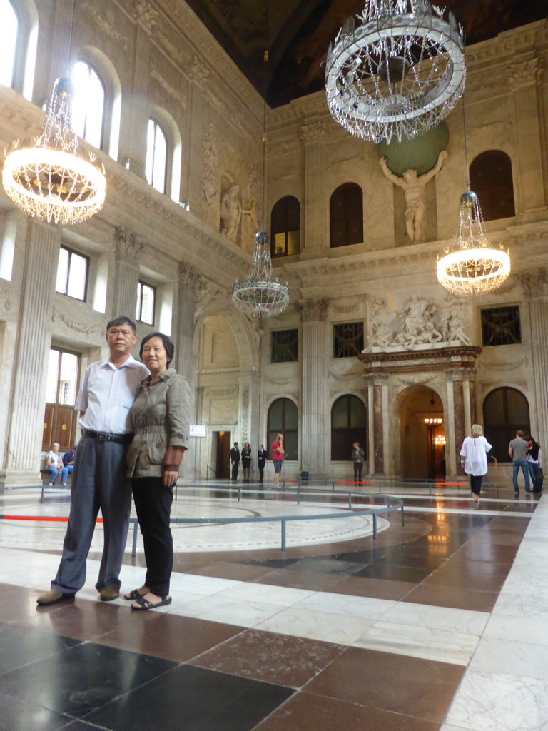 Miaomiao`s parents and the Atlas statue at the west side of the Citizen`s Hall at the First Floor of the Royal Palace Amsterdam