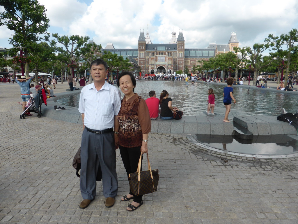 Miaomiao`s parents in front of the pond and the `I amsterdam` text at the southwest side of the Rijksmuseum at the Museumplein square