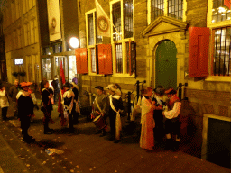 People in 17th century clothes, in front of Museum Het Rembrandthuis at the Jodenbreestraat street, by night