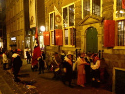 People in 17th century clothes, in front of Museum Het Rembrandthuis at the Jodenbreestraat street, by night