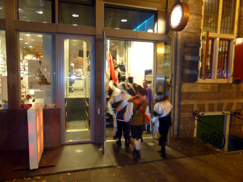 People in 17th century clothes, in front of Museum Het Rembrandthuis at the Jodenbreestraat street, by night