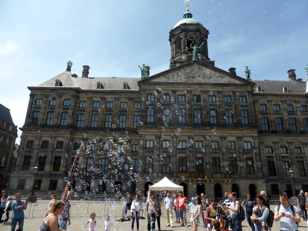People blowing bubbles in front of the Royal Palace Amsterdam at the Dam square