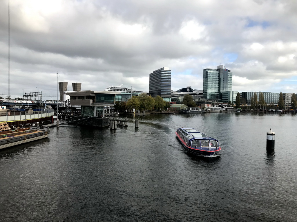 Boat in the Oosterdok canal, the Muziekgebouw aan `t IJ building, the Mövenpick Hotel Amsterdam City Centre, the UP Office Building and a cruise ship, viewed from the Mr. J.J. van der Veldebrug bridge