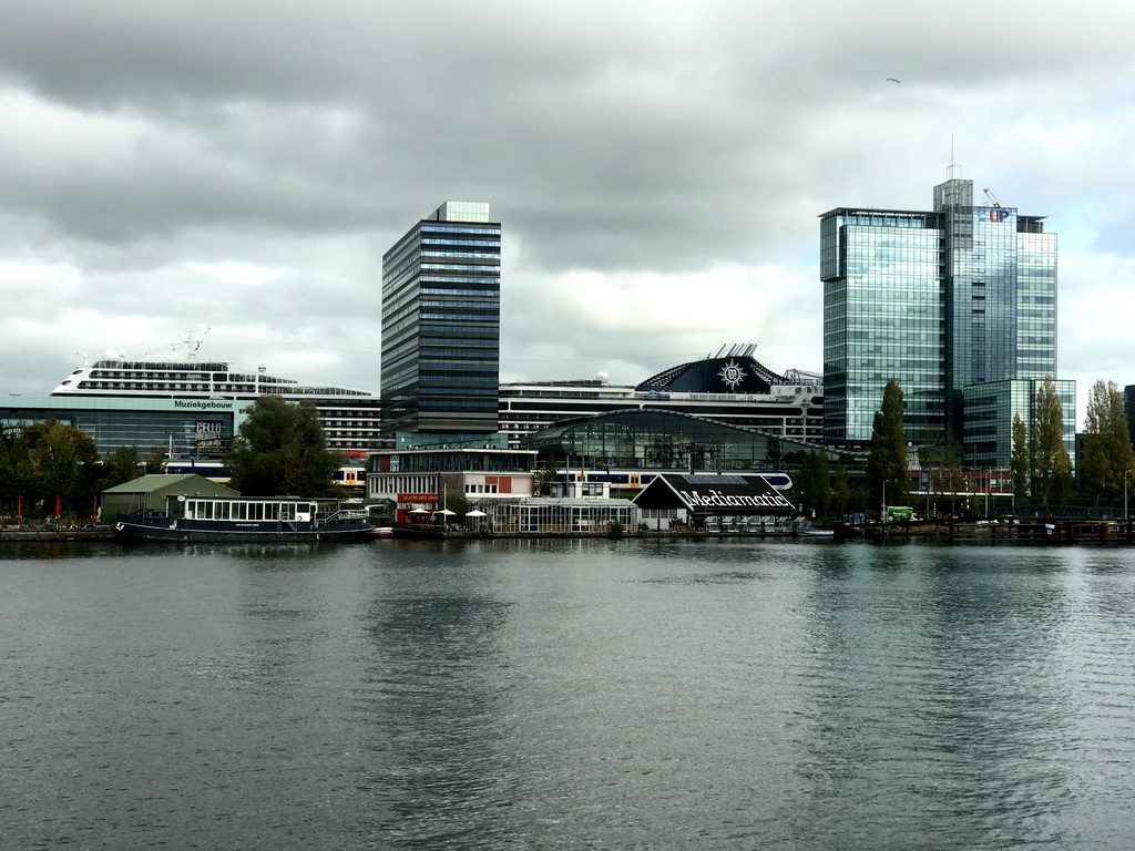 Boat in the Oosterdok canal, the Muziekgebouw aan `t IJ building, the Mövenpick Hotel Amsterdam City Centre, the UP Office Building and a cruise ship, viewed from the Mr. J.J. van der Veldebrug bridge