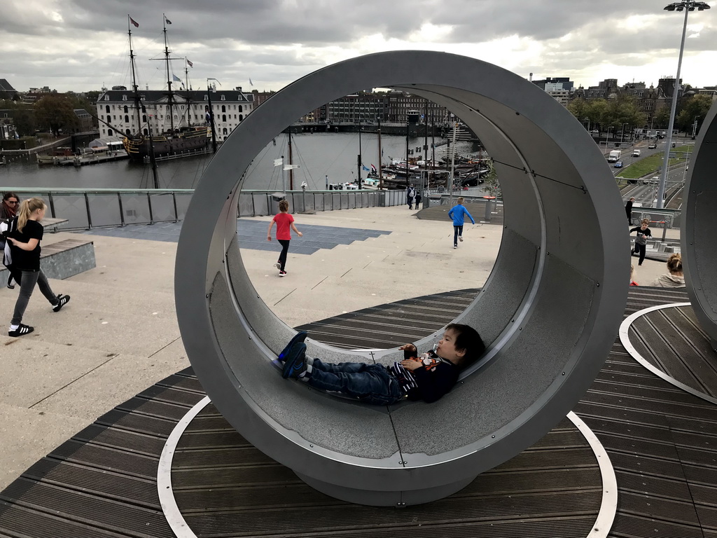 Max at the Solar Island at the Energetica exhibition at the roof at the Fifth Floor of the NEMO Science Museum, with a view on the Oosterdok canal and the National Maritime Museum with the replica of the `Amsterdam` ship