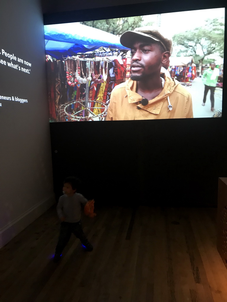 Max and a screen at the Fashion Cities Africa exhibition at the Second Floor of the Tropenmuseum