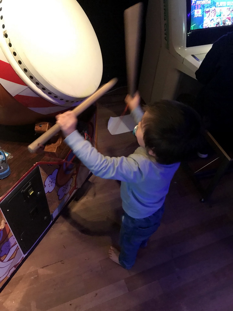Max playing with drums at an arcade game at the Cool Japan exhibition at the Second Floor of the Tropenmuseum