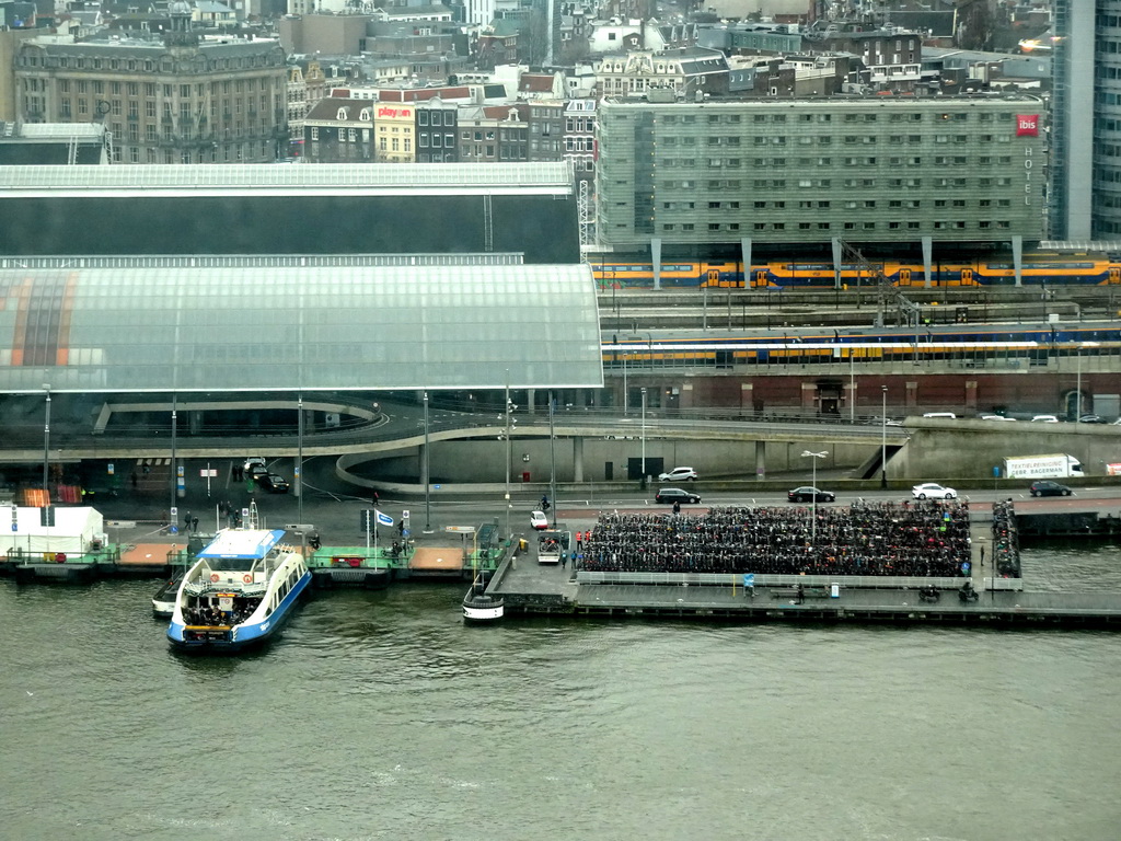 Ferry at the Central Station terminal at the IJ river and the Amsterdam Central Railway Station, viewed from the A`DAM Lookout Indoor observation deck at the A`DAM Tower