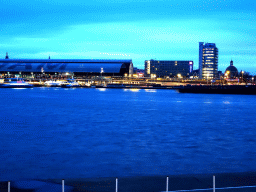 Boats in the IJ river, the Amsterdam Central Railway Station, the Hotel Ibis Amsterdam Centre, the Silver Tower and the Renaissance Koepelkerk conference center, viewed from the IJpromenade, at sunset