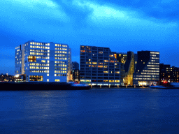 Boats in the IJ river and buildings at the IJdock area, viewed from the IJpromenade, at sunset