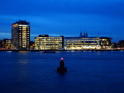 Boats in the IJ river and buildings at the De Ruijterkade street, viewed from the IJpromenade, at sunset