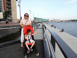 Miaomiao and Max at the Oosterdokskade street, with a view on the Mr. J.J. van der Veldebrug bridge over the Oosterdok canal and the front of the NEMO Science Museum