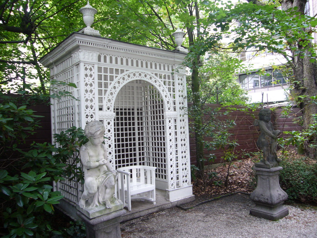 Statues and chair at the garden of the Huis met de Kolommen building