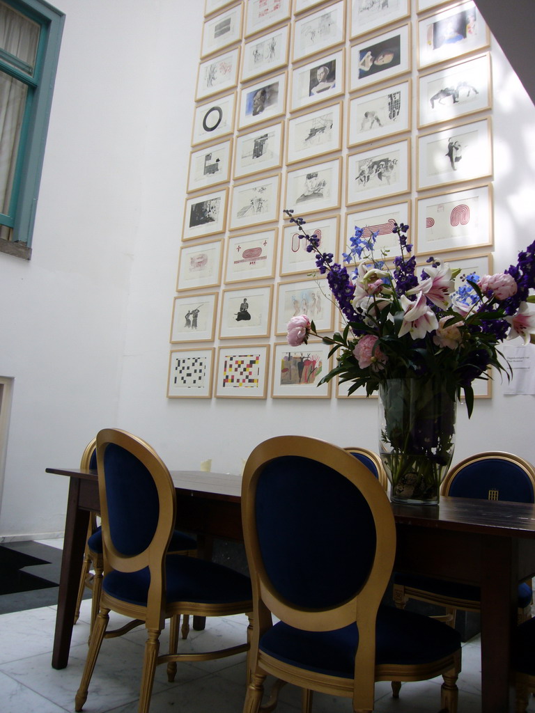 Table, chairs and a wall with art at a building at the Herengracht street