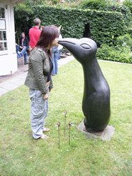 Miaomiao with a penguin statue at the garden of a building at the Herengracht street