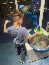 Max filling a bucket with water at the Energize game at the Technium exhibition at the Second Floor of the NEMO Science Museum
