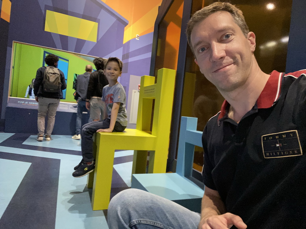 Tim on a small chair and Max on a large chair at the Technium exhibition at the Second Floor of the NEMO Science Museum
