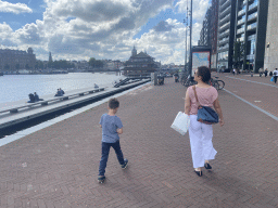 Miaomiao and Max on the Oosterdokskade street, with a view on the Oosterdok canal, the Grand Hotel Amrâth Amsterdam, the Oude Kerk church, the Sea Palace restaurant and the Basilica of Saint Nicholas