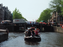 The Prinsengracht canal, with the bridge at the crossing of the Westermarkt square, and people with wooden shoes on a fishing pole