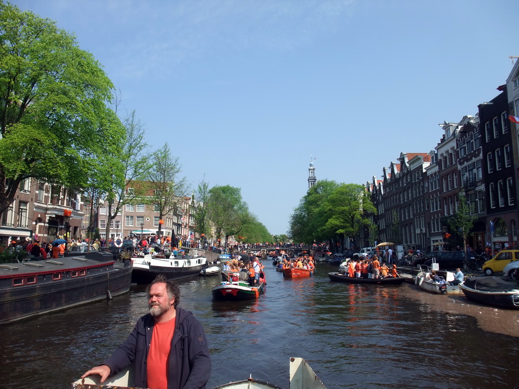 The skipper on the tour boat at the Prinsengracht canal, with the bridge at the crossing of the Reestraat street and the Westerkerk church