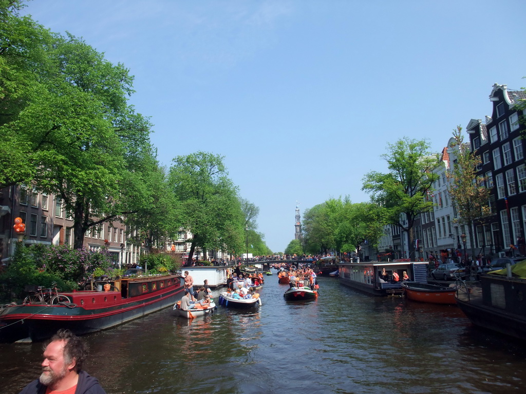 The skipper on the tour boat at the Prinsengracht canal, with the bridge at the crossing of the Berenstraat street and the Westerkerk church