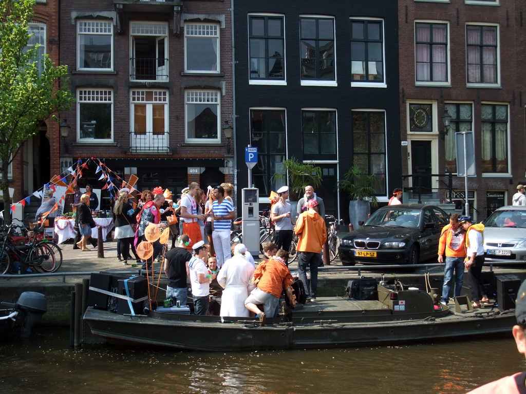 Houses, tour boat and open market at the Prinsengracht canal