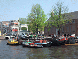 Boats at the Amstel river, the bridge at the crossing of the Nieuwe Herengracht canal and the Hermitage Amsterdam museum