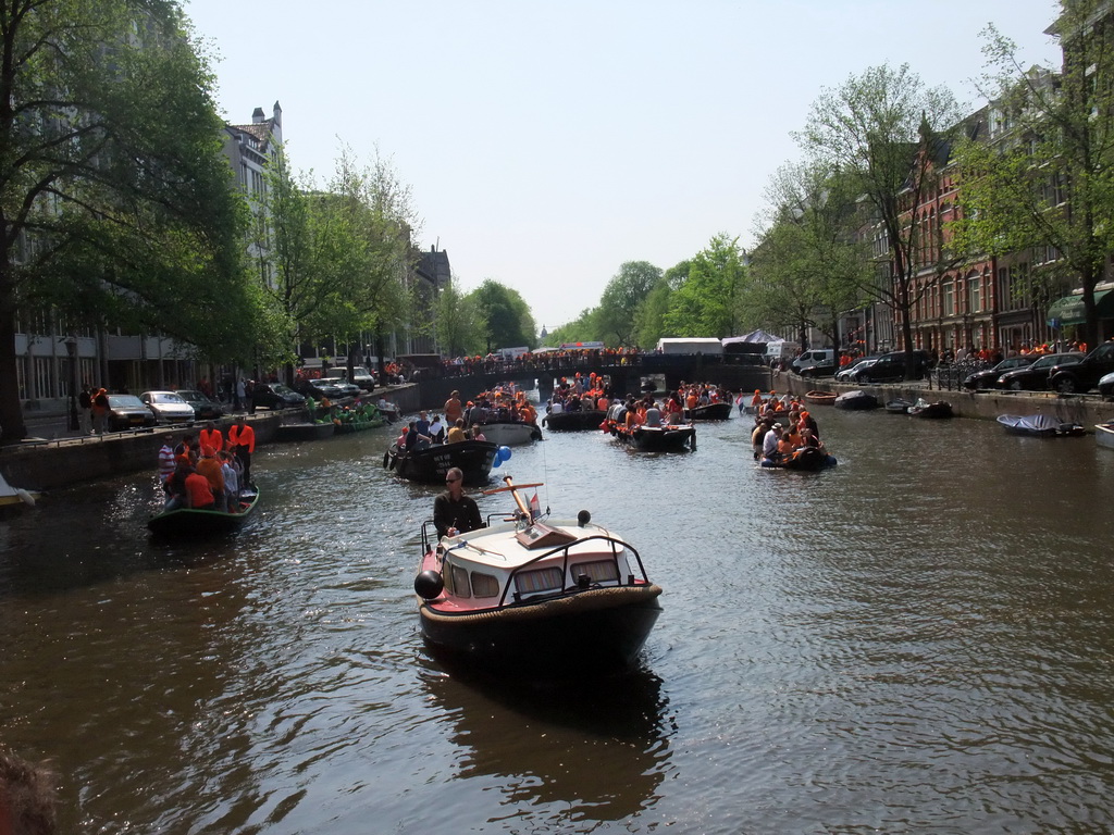 Boats at the Singel canal with the bridge at the crossing of the Raadhuisstraat street