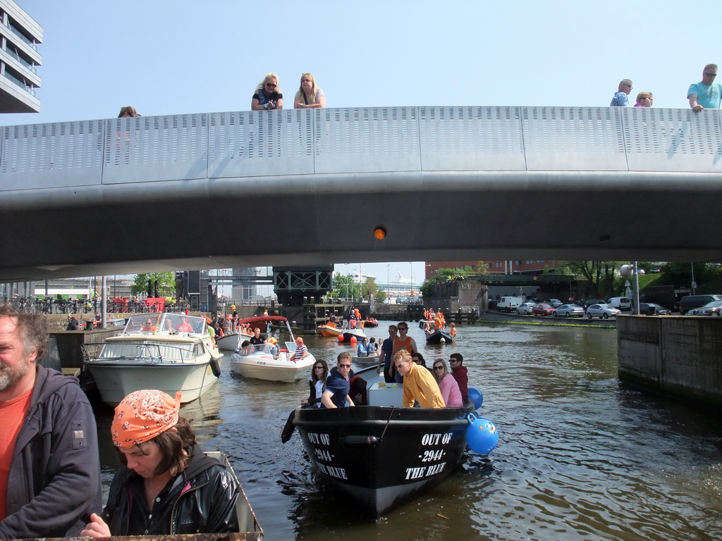 The skipper on the tour boat at the Westerdok canal with the Han Lammersbrug bridge