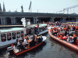 Tour boats at the Westerdok canal with the railway crossing and the towers of the Posthoornkerk church