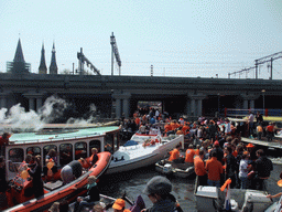 Tour boats at the Westerdok canal with the railway crossing and the towers of the Posthoornkerk church