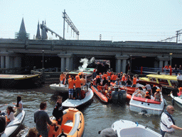 Tour boats at the Westerdok canal with the railway crossing and the towers of the Posthoornkerk church