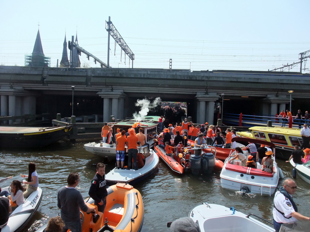 Tour boats at the Westerdok canal with the railway crossing and the towers of the Posthoornkerk church