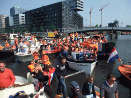 The skipper on the tour boat at the Westerdok canal with the Han Lammersbrug bridge