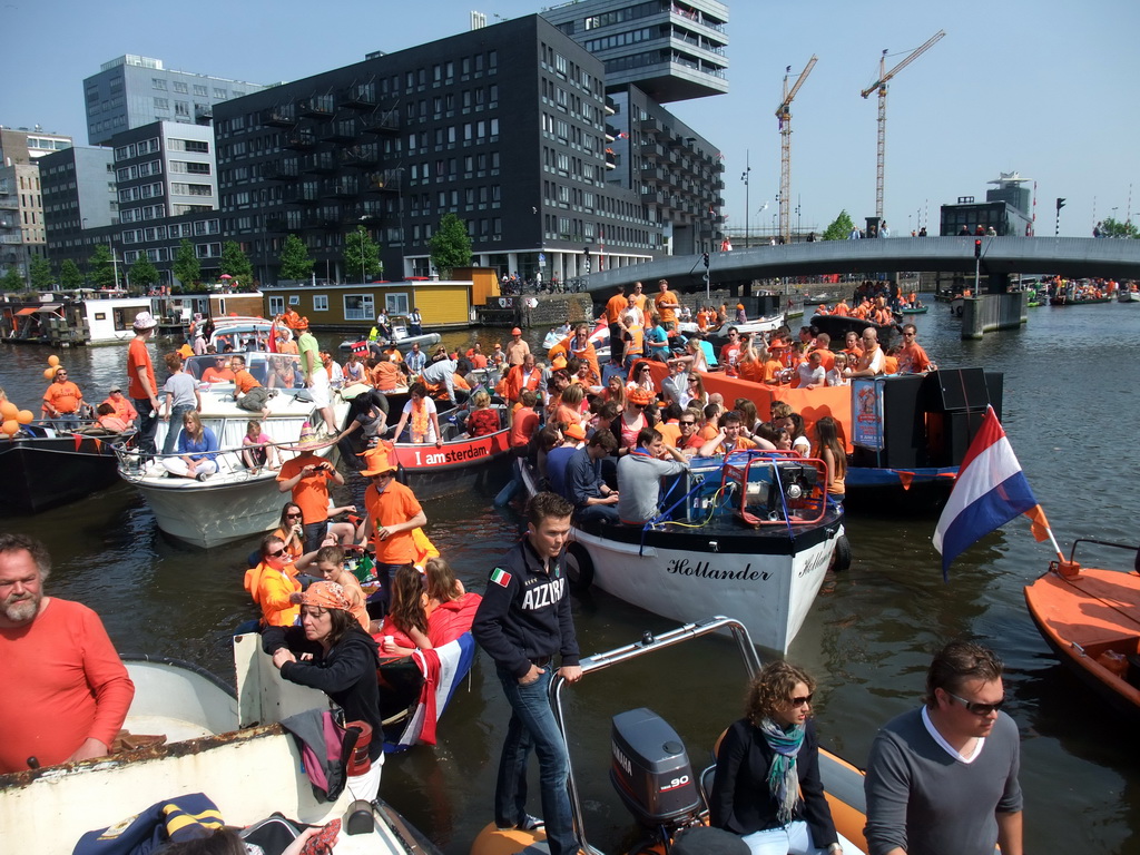 The skipper on the tour boat at the Westerdok canal with the Han Lammersbrug bridge