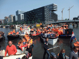 The skipper on the tour boat at the Westerdok canal with the Han Lammersbrug bridge